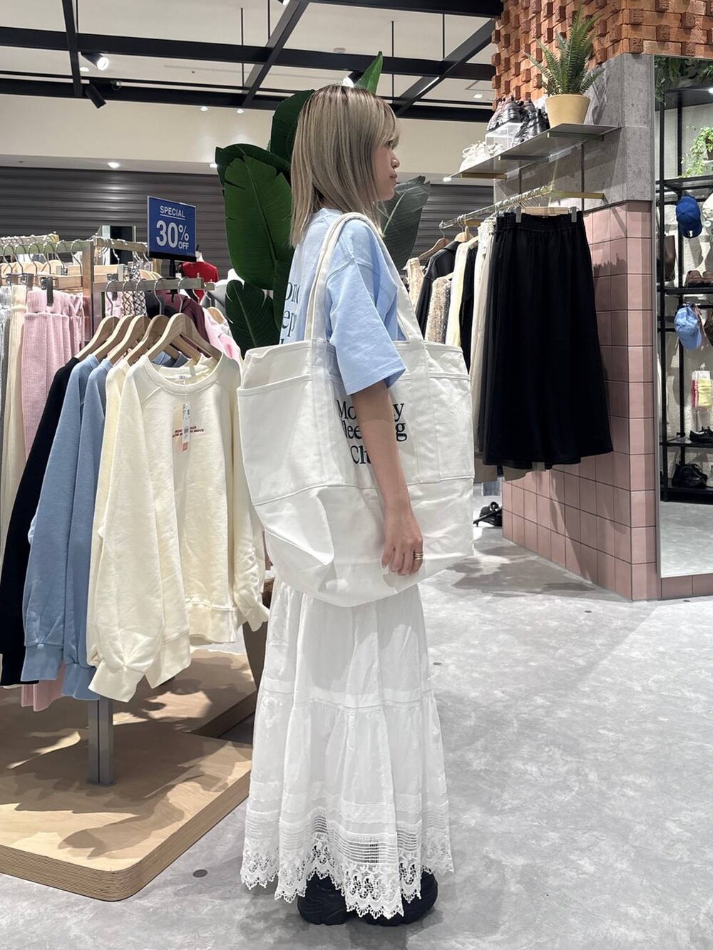 ブラック系のローファー、ブルー系のTシャツ/カットソー、ホワイト系のスカートを着用したレディースの春コーディネートの2枚目の写真