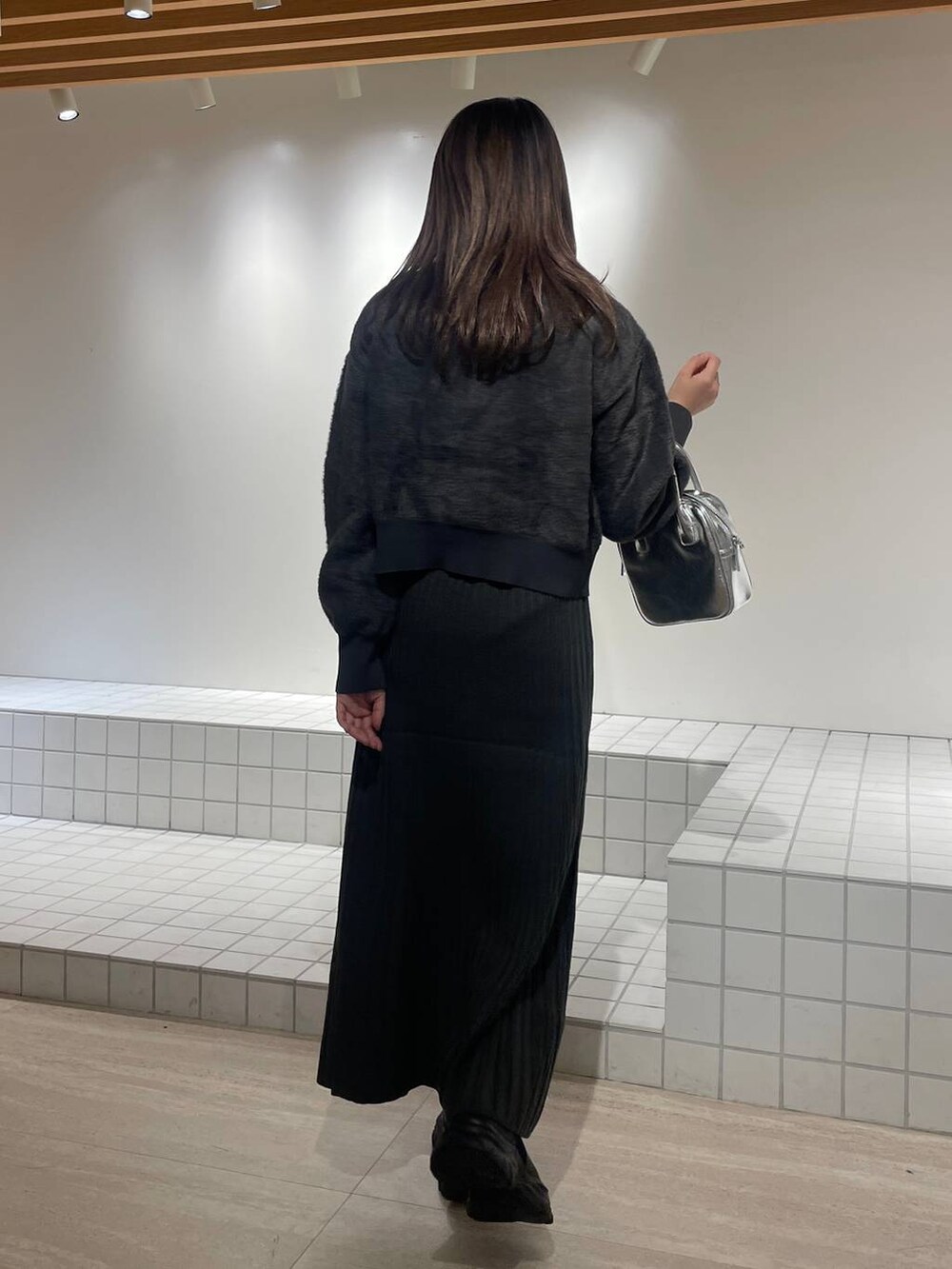 ブルー系のニット/セーター、グレー系のワンピース、シルバー系のボストンバッグを着用したレディースの冬コーディネートの3枚目の写真