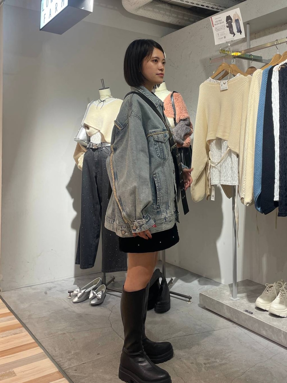 ブラック系のボディバッグ/ウエストポーチ、ブルー系のデニムジャケット、ブラック系のブーツを着用したレディースの秋コーディネートの2枚目の写真