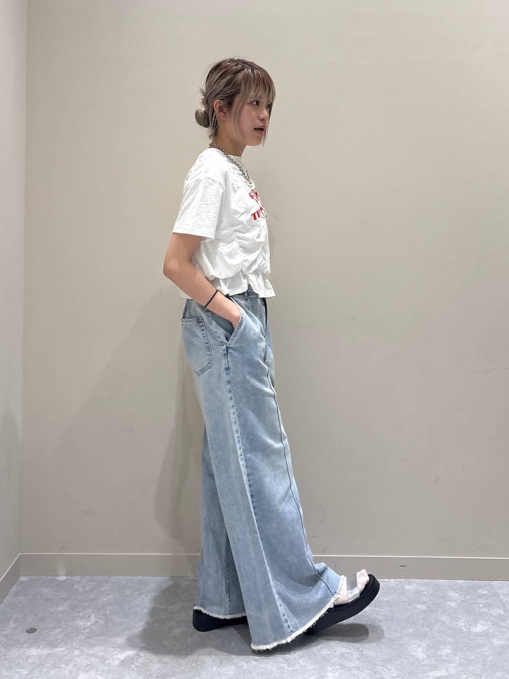 ブルー系のデニムパンツ、シルバー系のサンダル、ホワイト系のTシャツ/カットソーを着用したレディースの春コーディネートの4枚目の写真