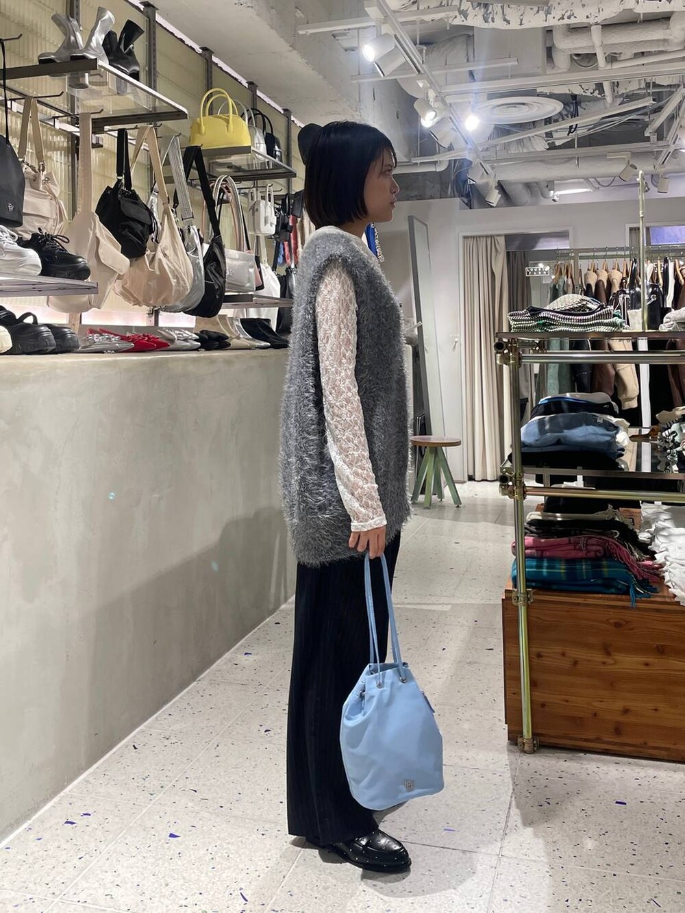 ブルー系のスラックス、グレー系のベスト、ブラック系のローファーを着用したレディースの秋コーディネートの2枚目の写真