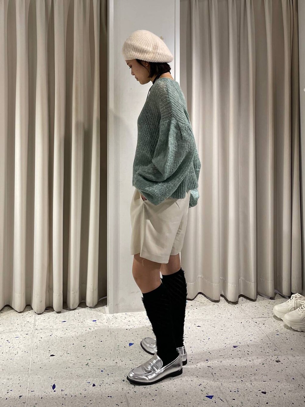 ホワイト系のその他パンツ、シルバー系のローファー、グリーン系のニット/セーターを着用したレディースの秋コーディネートの2枚目の写真