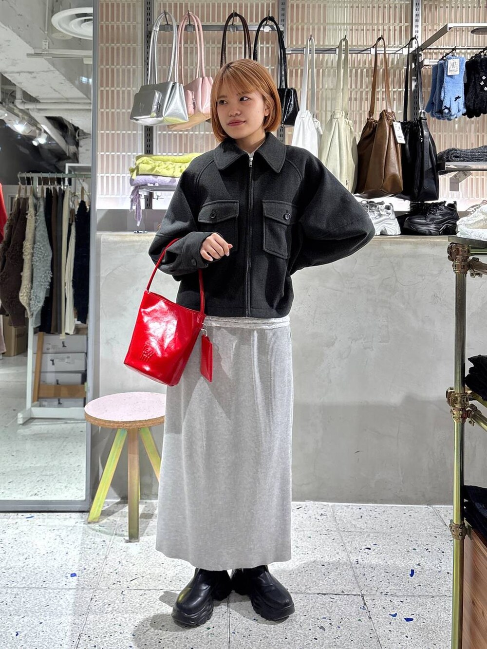 グレー系のスカート、ブラック系のブーツ、ホワイト系のTシャツ/カットソーを着用したレディースの冬コーディネートの5枚目の写真