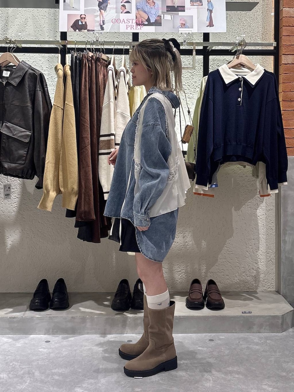 ブルー系のシャツ/ブラウス、ベージュ系のブーツ、ブラック系のショルダーバッグを着用したレディースの春コーディネートの2枚目の写真