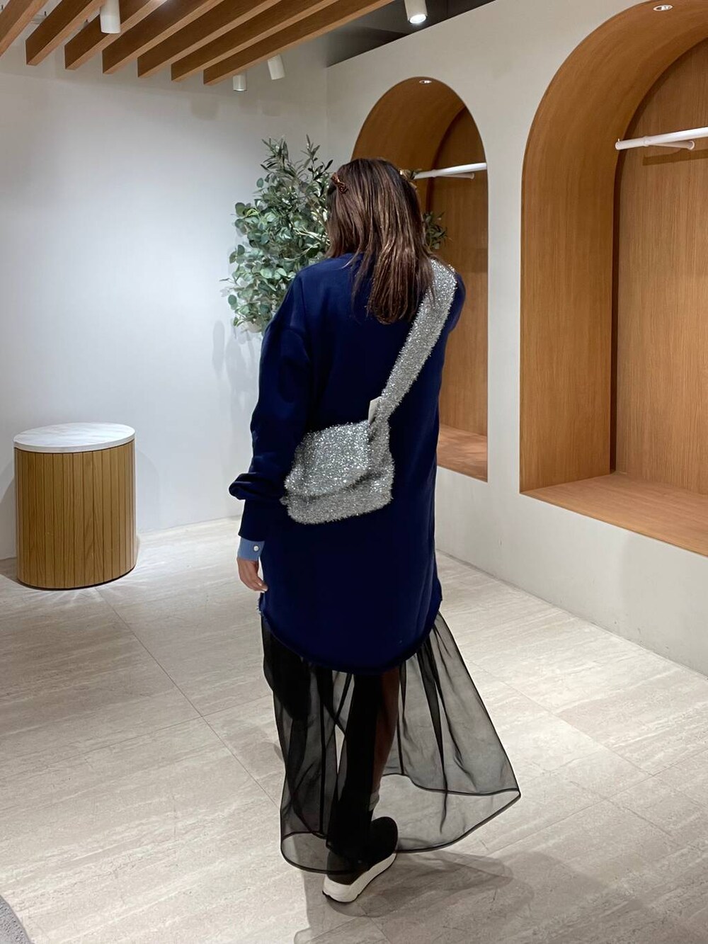 ブルー系のニット/セーター、ブラック系のショルダーバッグ、シルバー系のショルダーバッグを着用したレディースの冬コーディネートの4枚目の写真