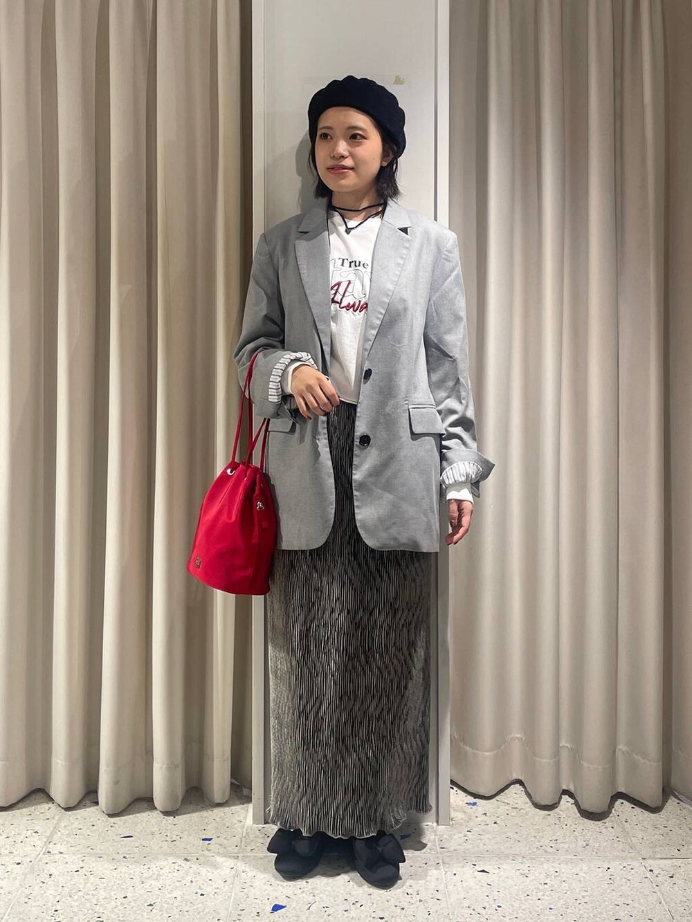 グレー系のテーラードジャケット、グレー系のスカート、ホワイト系のTシャツ/カットソーを着用したレディースの秋コーディネートの4枚目の写真