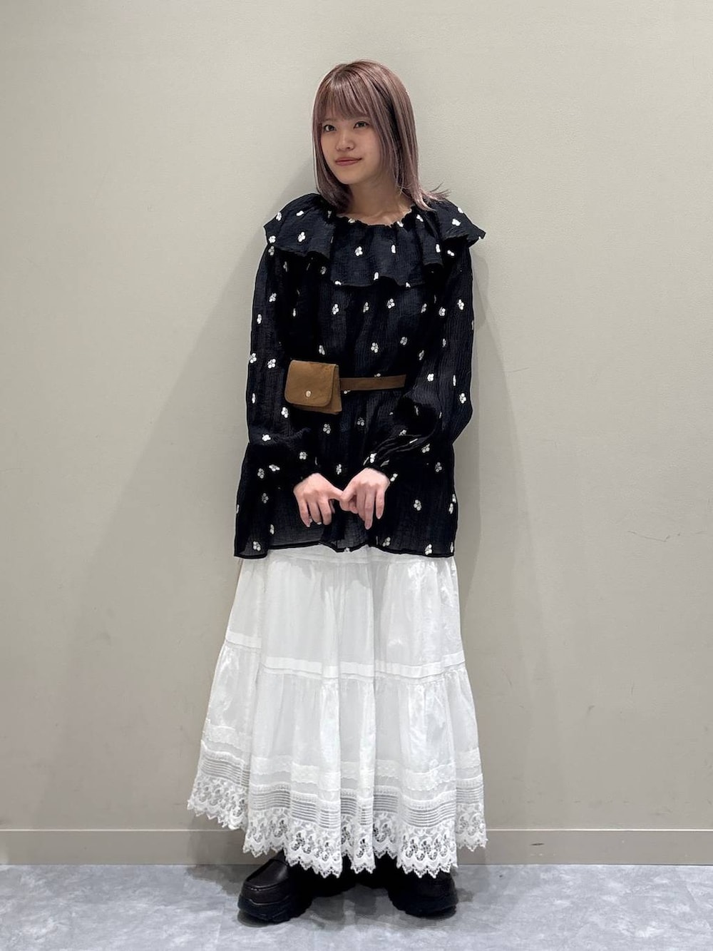 ブラウン系のローファー、ホワイト系のスカート、ブラック系のワンピースを着用したレディースの春コーディネートの5枚目の写真