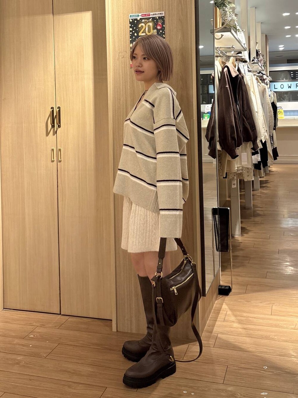 ブラウン系のハンドバッグ、ホワイト系のその他パンツ、ブラウン系のブーツを着用したレディースの秋コーディネートの2枚目の写真