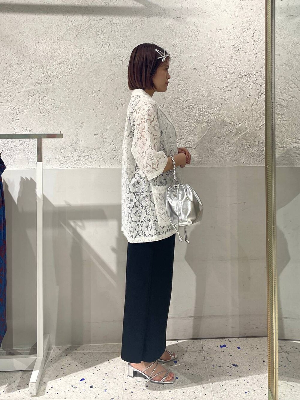 ブラック系のスカート、シルバー系のサンダル、ホワイト系のシャツ/ブラウスを着用したレディースの春コーディネートの4枚目の写真