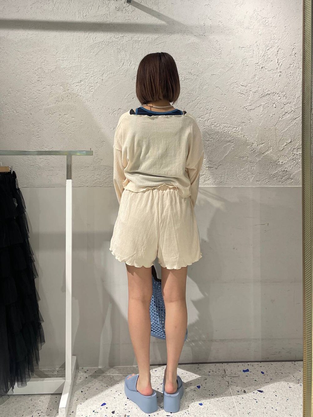 ブルー系のショルダーバッグ、ブルー系のサンダル、ブルー系のタンクトップを着用したレディースの春コーディネートの5枚目の写真