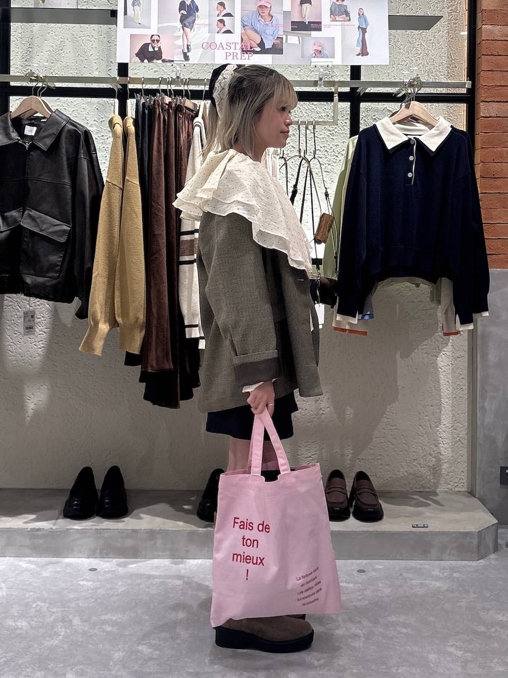 ブラウン系のテーラードジャケット、ベージュ系のブーツ、ピンク系のトートバッグを着用したレディースの春コーディネートの2枚目の写真