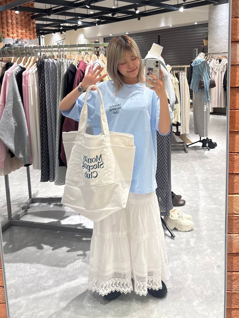 ブラック系のローファー、ブルー系のTシャツ/カットソー、ホワイト系のスカートを着用したレディースの春コーディネートの6枚目の写真