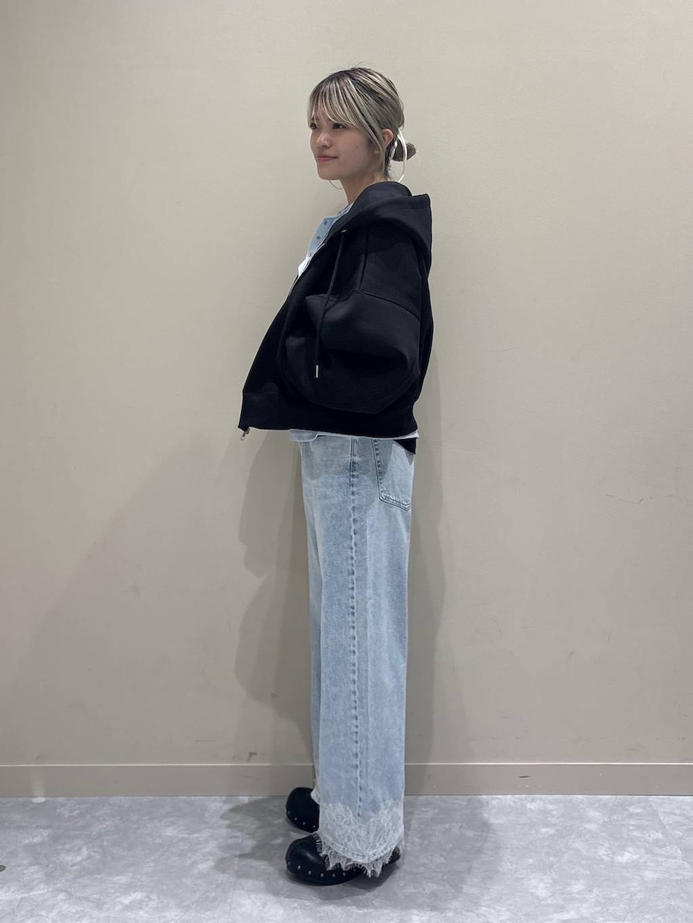 ブラック系のニット/セーター、ブラック系のパーカー、ブルー系のデニムパンツを着用したレディースの春コーディネートの2枚目の写真