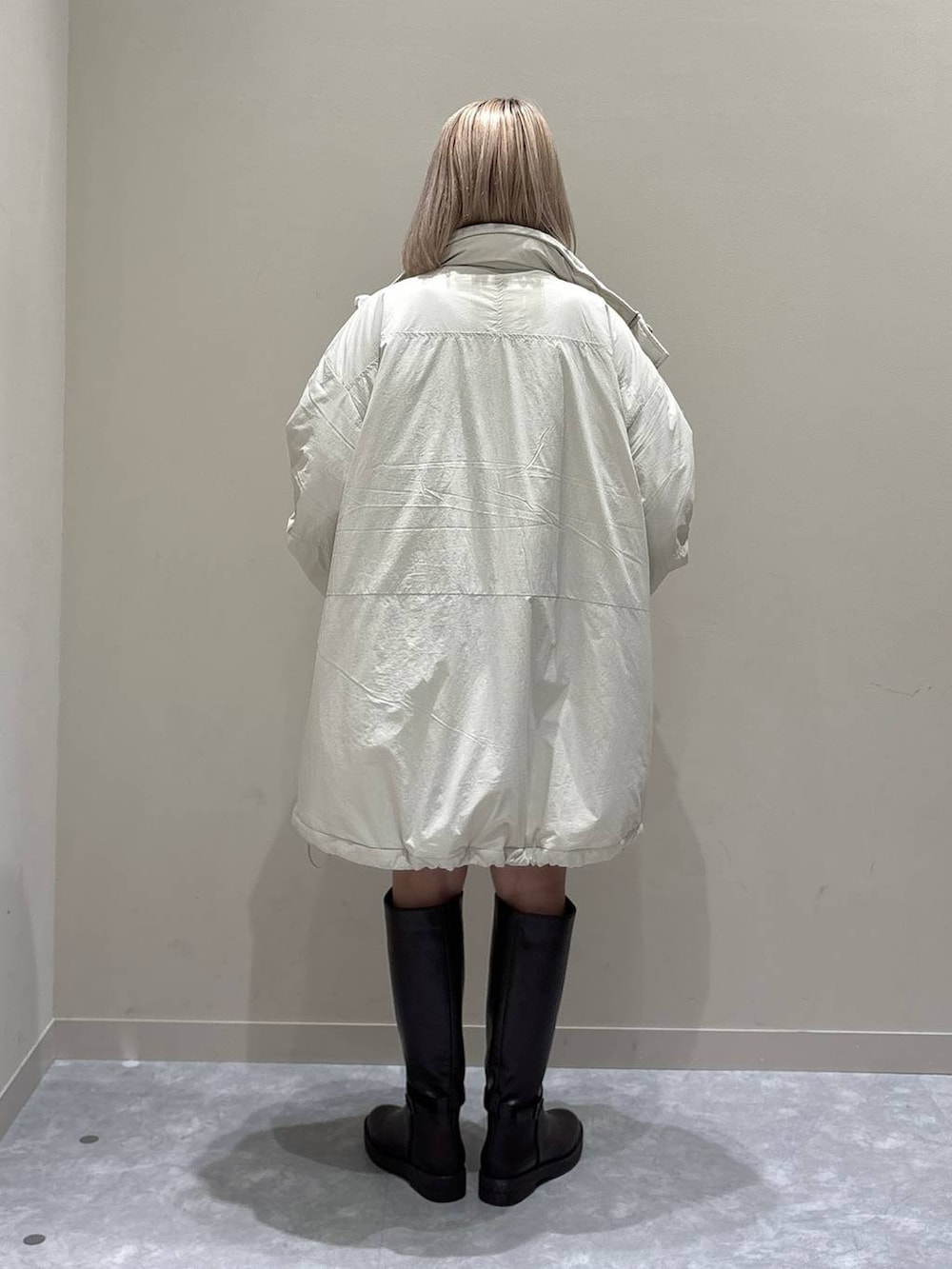 ブルー系のカーディガン/ボレロ、ホワイト系のブルゾン、ブラウン系のブーツを着用したレディースの秋コーディネートの3枚目の写真