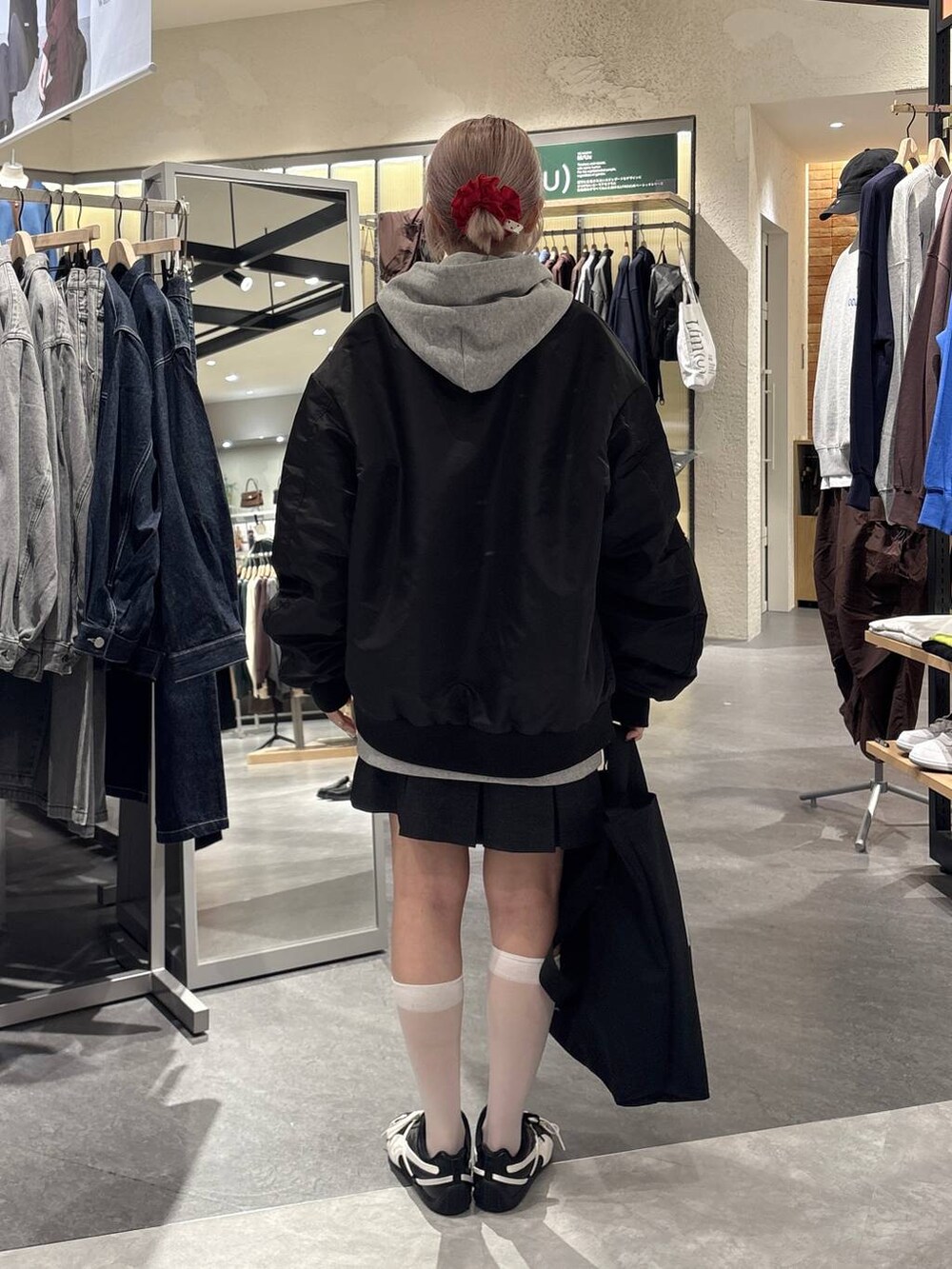 グレー系のスカート、グレー系のTシャツ/カットソー、ブラック系のブルゾンを着用したレディースの秋コーディネートの4枚目の写真