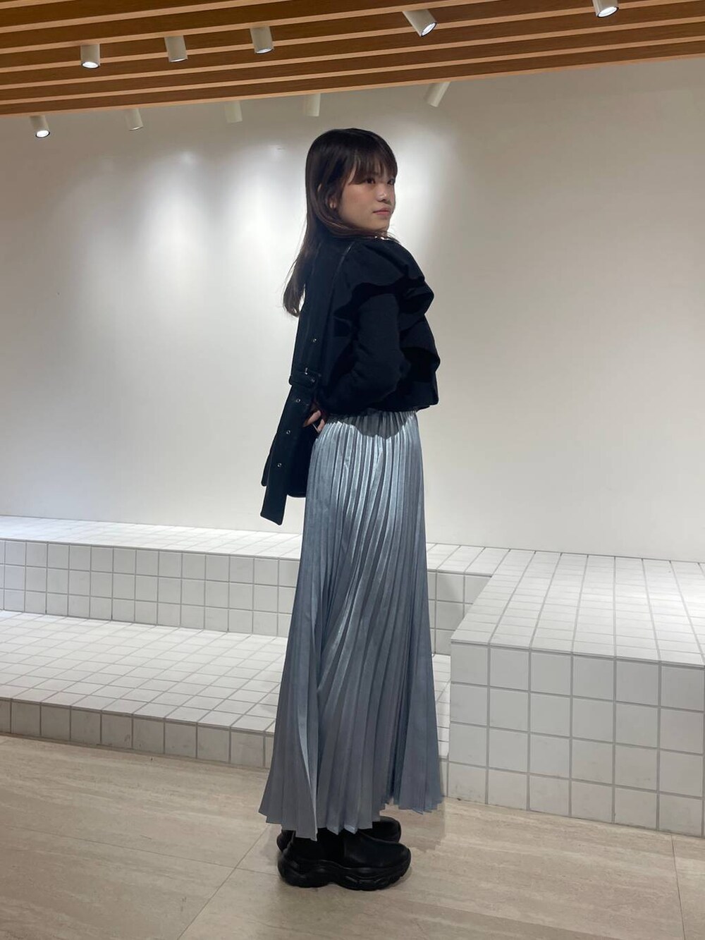 ブラック系のニット/セーター、ブラック系のショルダーバッグ、ブラック系のブーツを着用したレディースの冬コーディネートの3枚目の写真