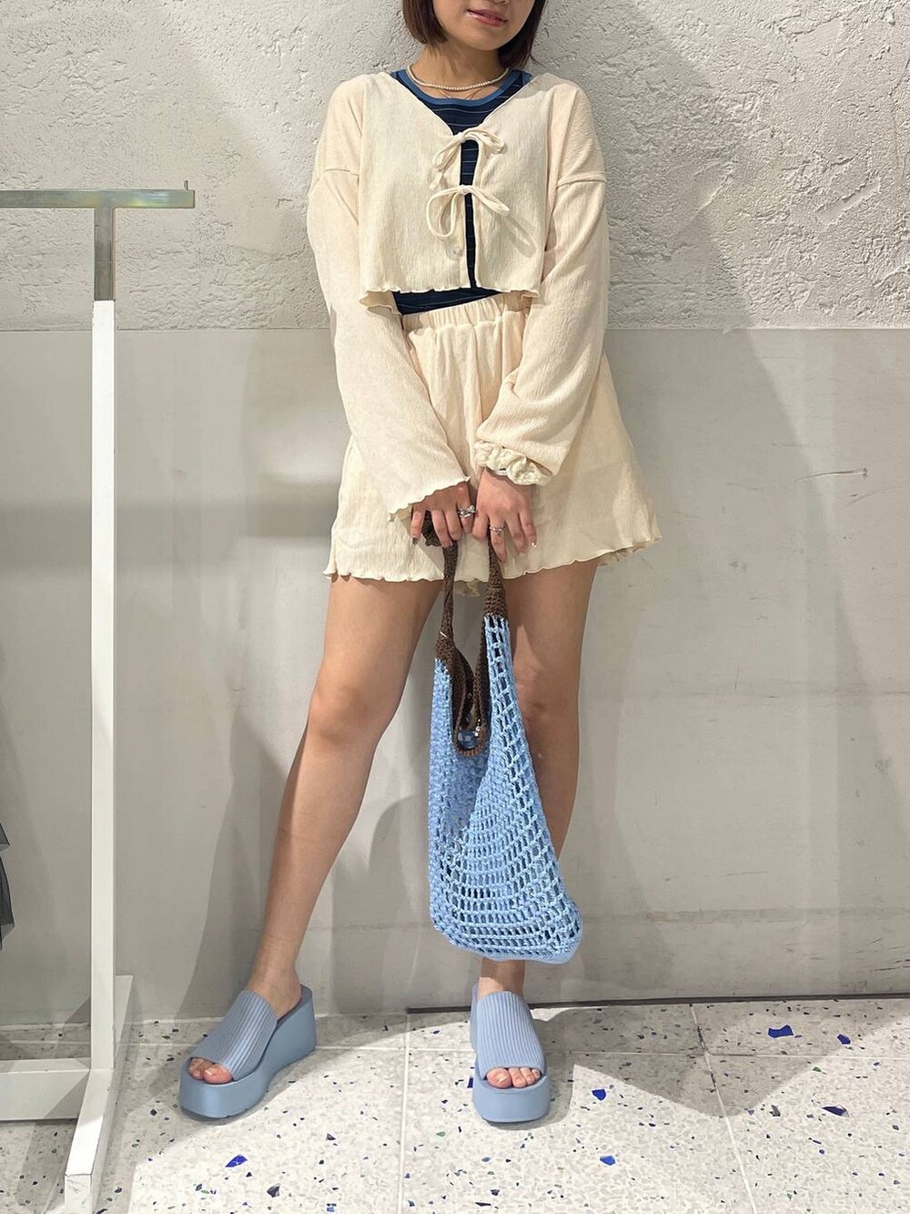 ブルー系のショルダーバッグ、ブルー系のサンダル、ブルー系のタンクトップを着用したレディースの春コーディネートの4枚目の写真