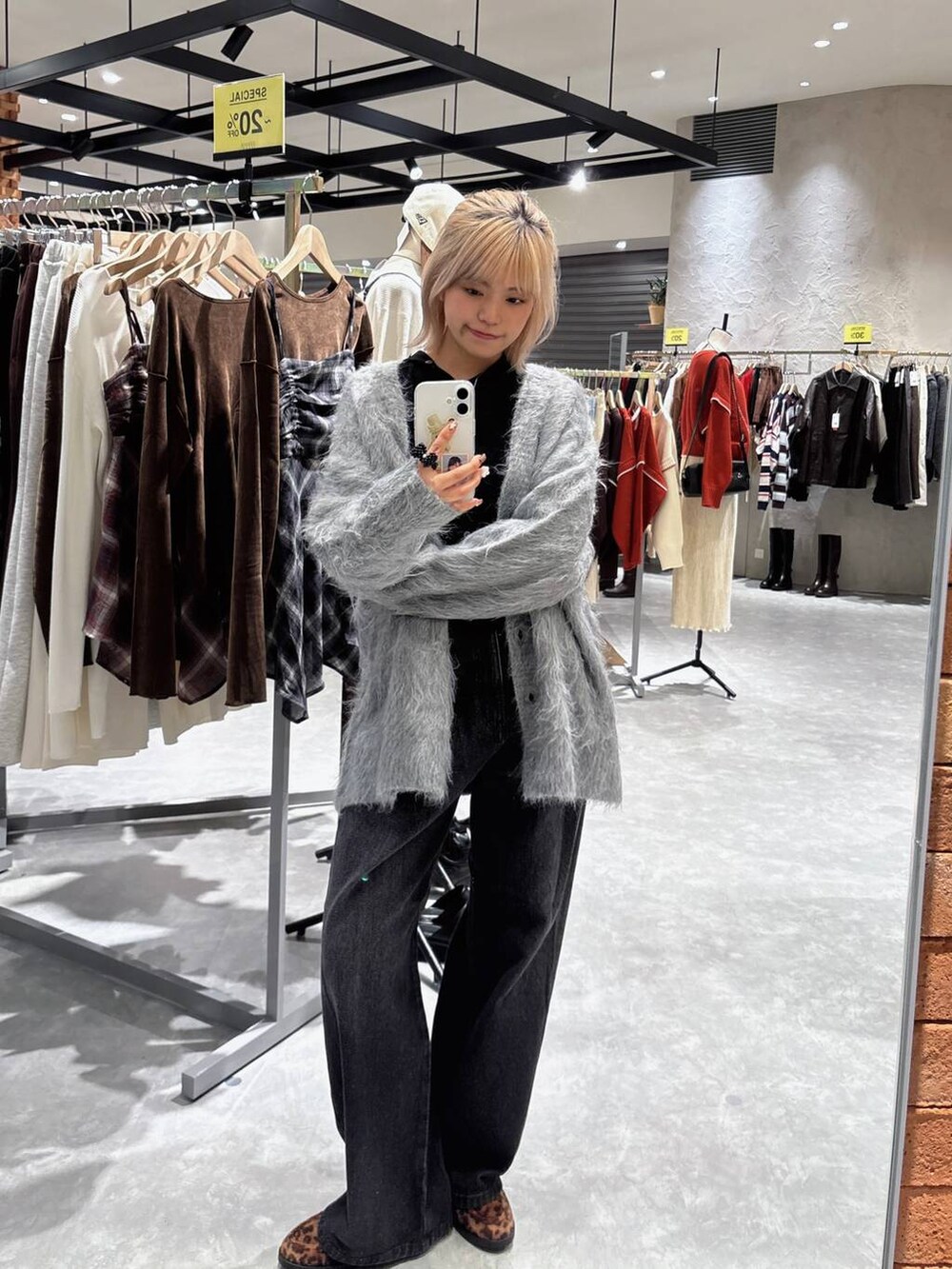 ブラック系のデニムパンツ、ブラック系のニット/セーター、グレー系のカーディガン/ボレロを着用したレディースの秋コーディネートの3枚目の写真