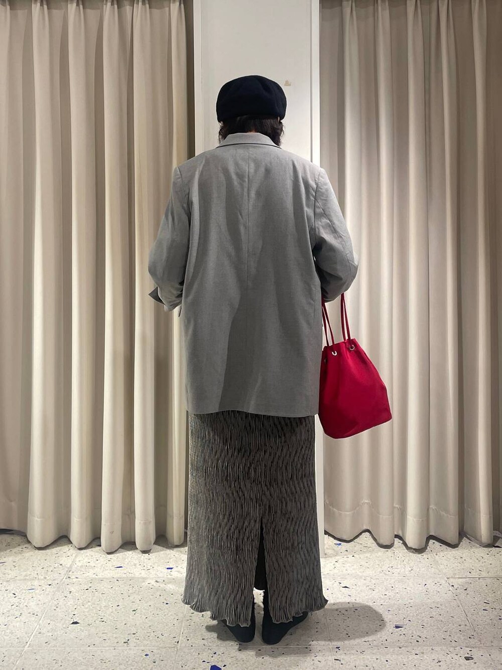 グレー系のテーラードジャケット、グレー系のスカート、ホワイト系のTシャツ/カットソーを着用したレディースの秋コーディネートの3枚目の写真