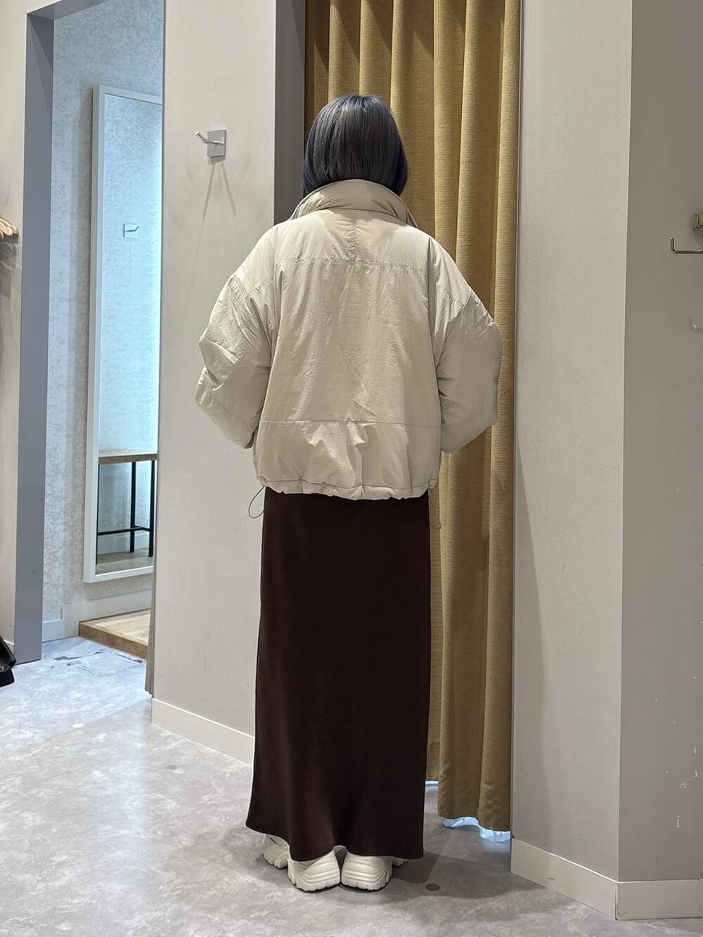 ホワイト系のその他アウター、ホワイト系のブーツ、ブラウン系のスカートを着用したレディースの冬コーディネートの3枚目の写真