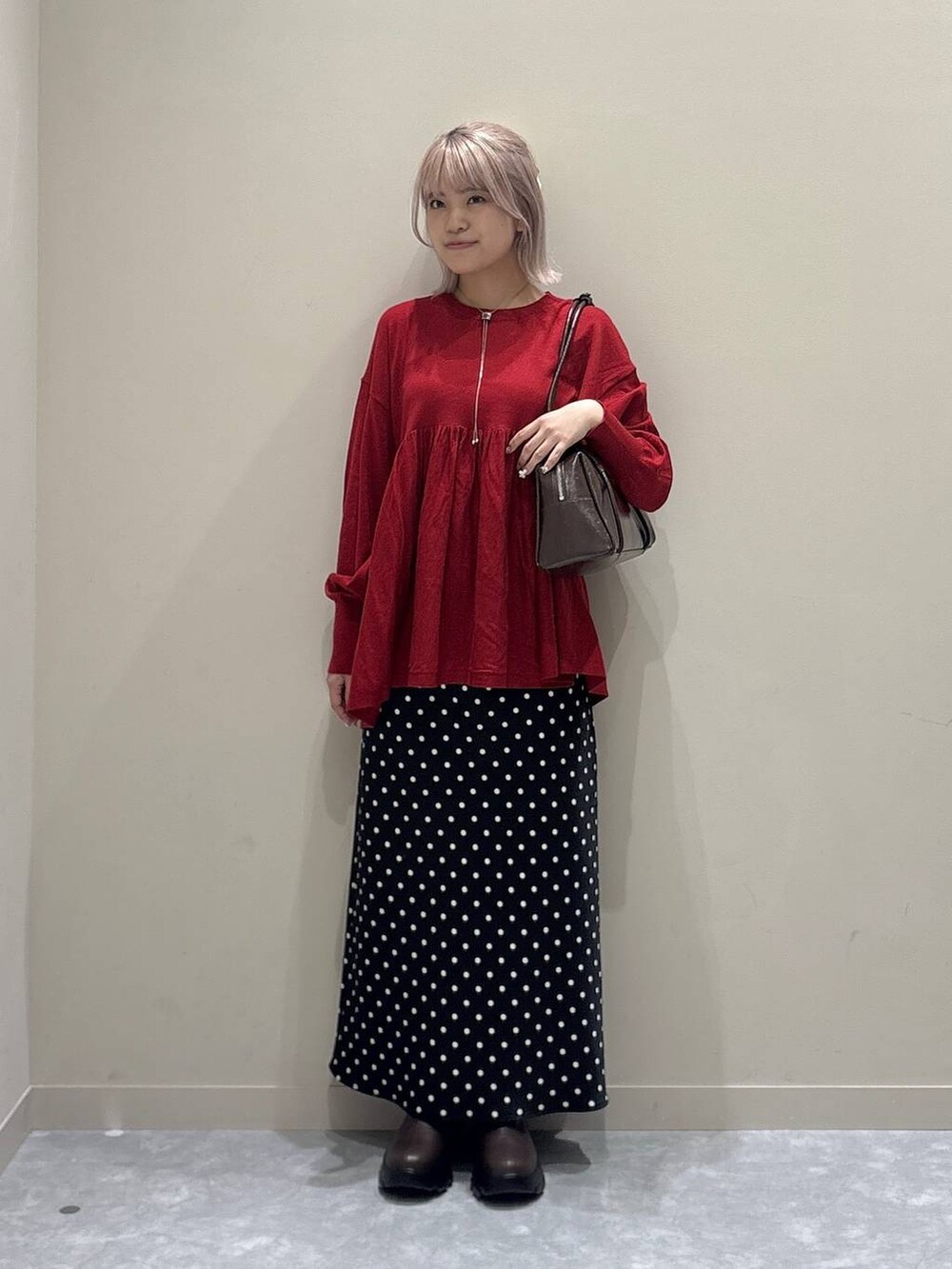 ブラック系のスカート、レッド系のニット/セーター、レッド系のボストンバッグを着用したレディースの秋コーディネートの5枚目の写真