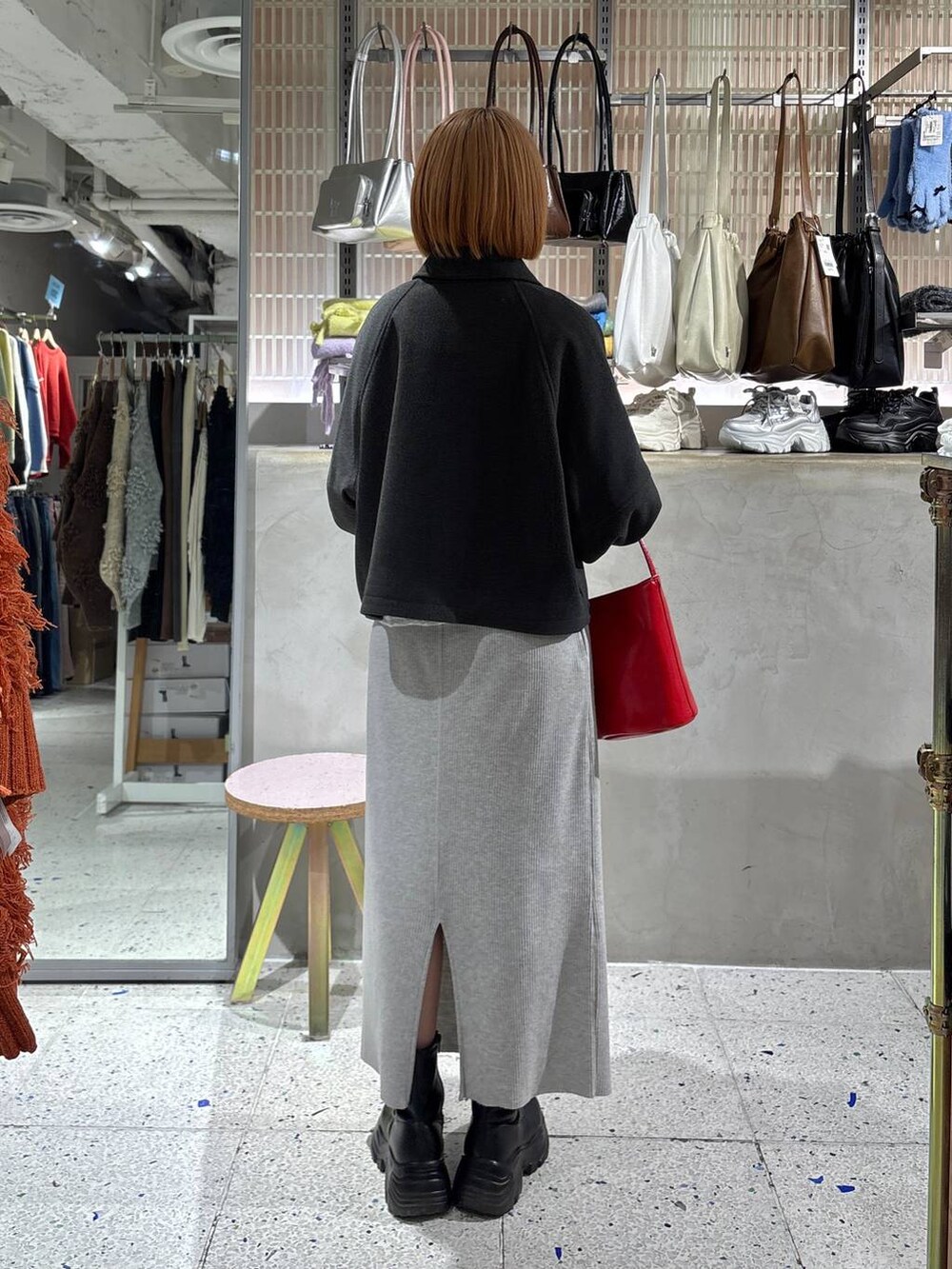 グレー系のスカート、ブラック系のブーツ、ホワイト系のTシャツ/カットソーを着用したレディースの冬コーディネートの3枚目の写真