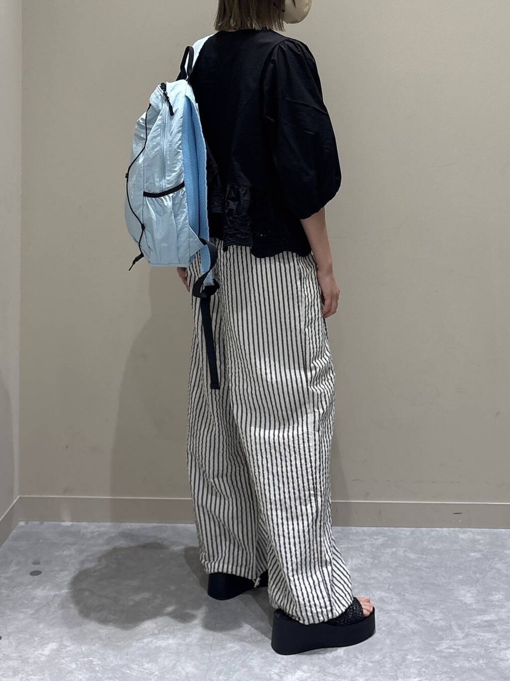 シルバー系のサンダル、ブラック系のシャツ/ブラウス、ブルー系のバックパック/リュックを着用したレディースの春コーディネートの6枚目の写真