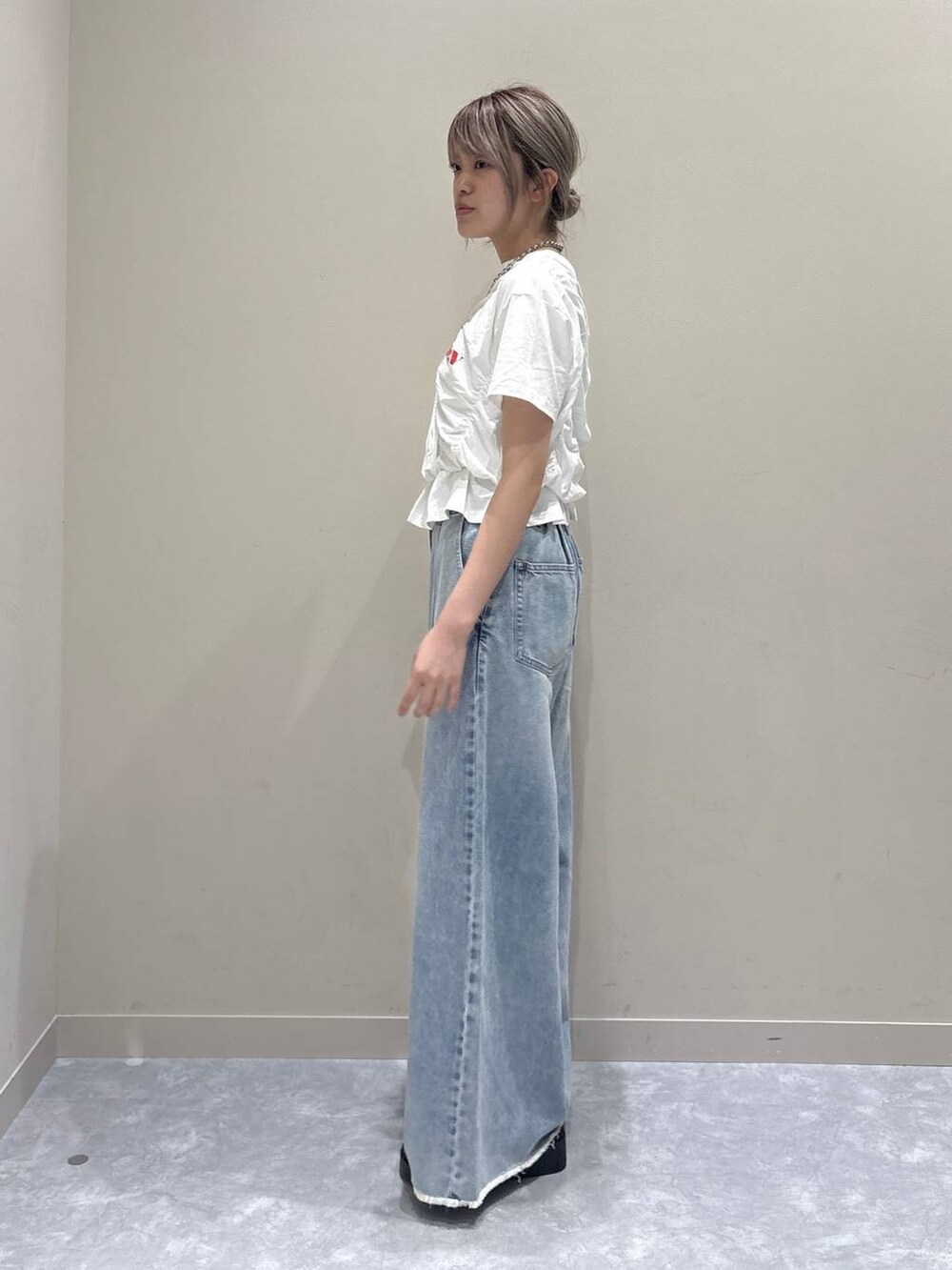 ブルー系のデニムパンツ、シルバー系のサンダル、ホワイト系のTシャツ/カットソーを着用したレディースの春コーディネートの2枚目の写真