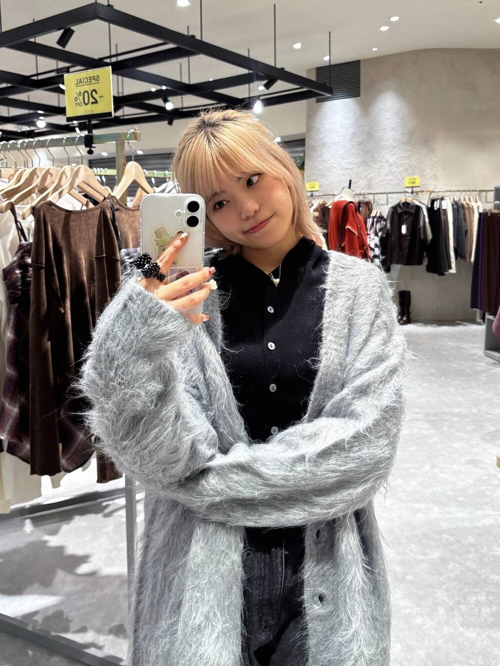 ブラック系のデニムパンツ、ブラック系のニット/セーター、グレー系のカーディガン/ボレロを着用したレディースの秋コーディネートの2枚目の写真