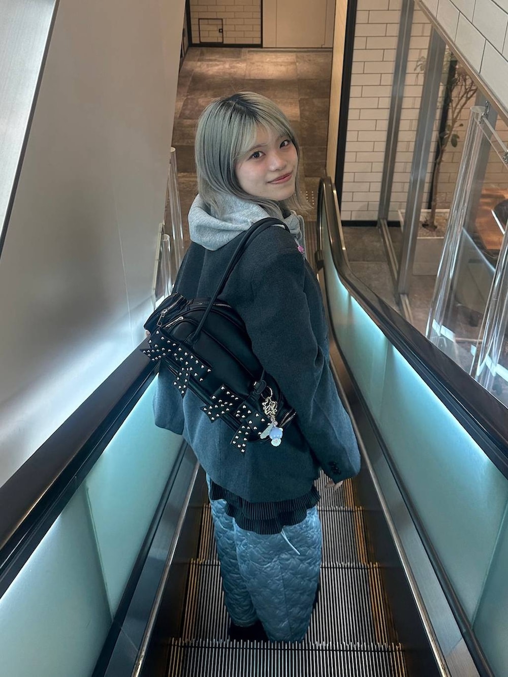 グレー系のテーラードジャケット、グレー系のパーカーを着用したレディースの冬コーディネートの2枚目の写真