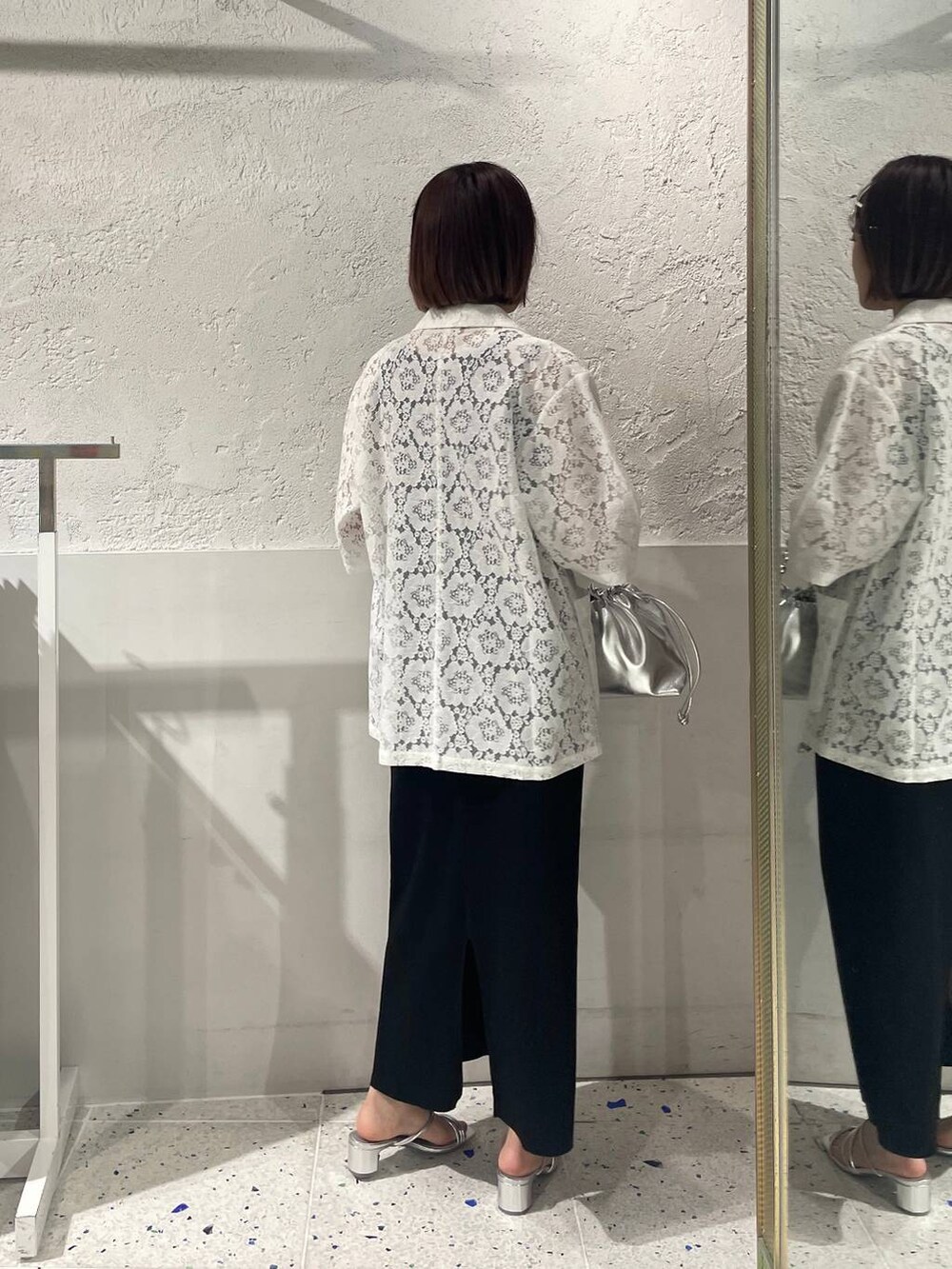 ブラック系のスカート、シルバー系のサンダル、ホワイト系のシャツ/ブラウスを着用したレディースの春コーディネートの3枚目の写真