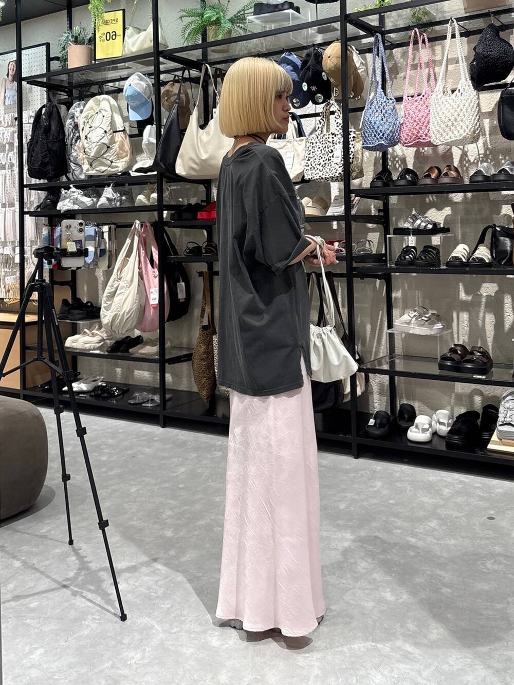 グレー系のスニーカー、ピンク系のスカート、ホワイト系のショルダーバッグを着用したレディースの夏コーディネートの2枚目の写真