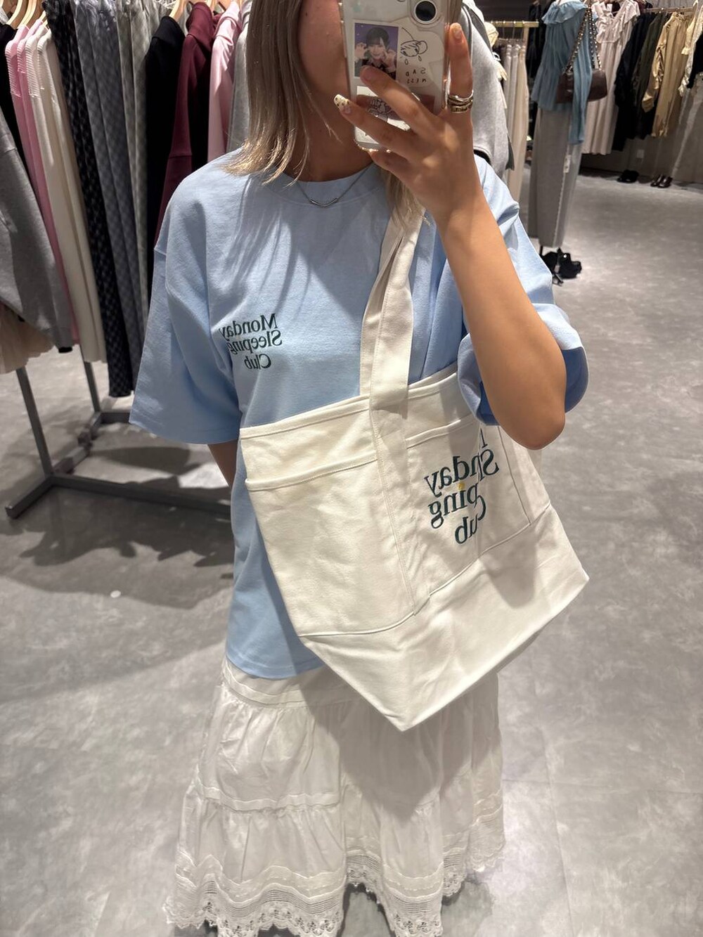 ブラック系のローファー、ブルー系のTシャツ/カットソー、ホワイト系のスカートを着用したレディースの春コーディネートの7枚目の写真