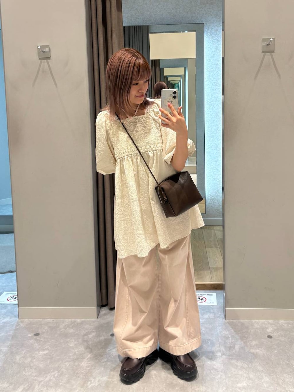 ピンク系のデニムパンツ、ブラウン系のローファー、ブラウン系のトートバッグを着用したレディースの春コーディネートの5枚目の写真