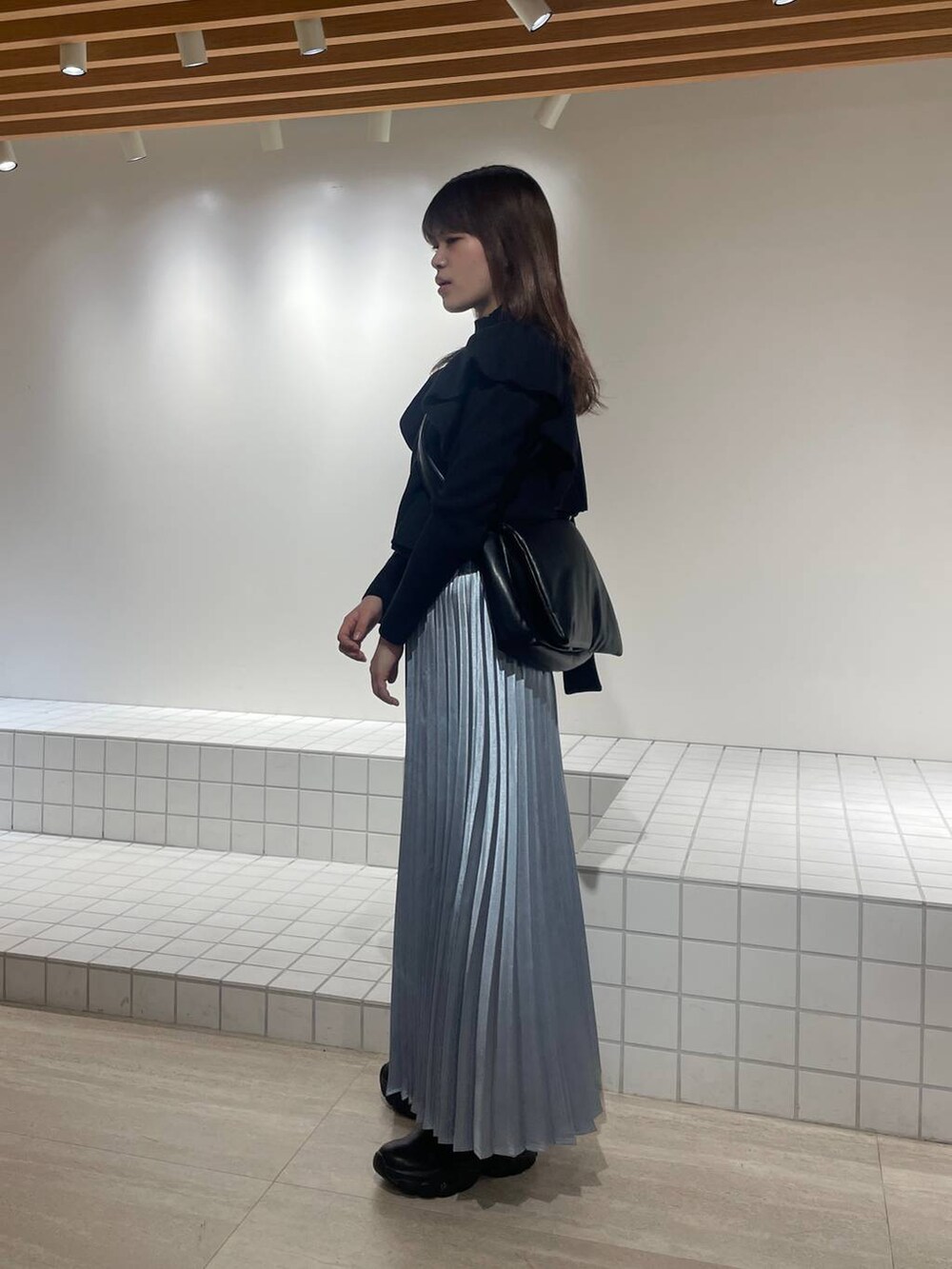 ブラック系のニット/セーター、ブラック系のショルダーバッグ、ブラック系のブーツを着用したレディースの冬コーディネートの2枚目の写真