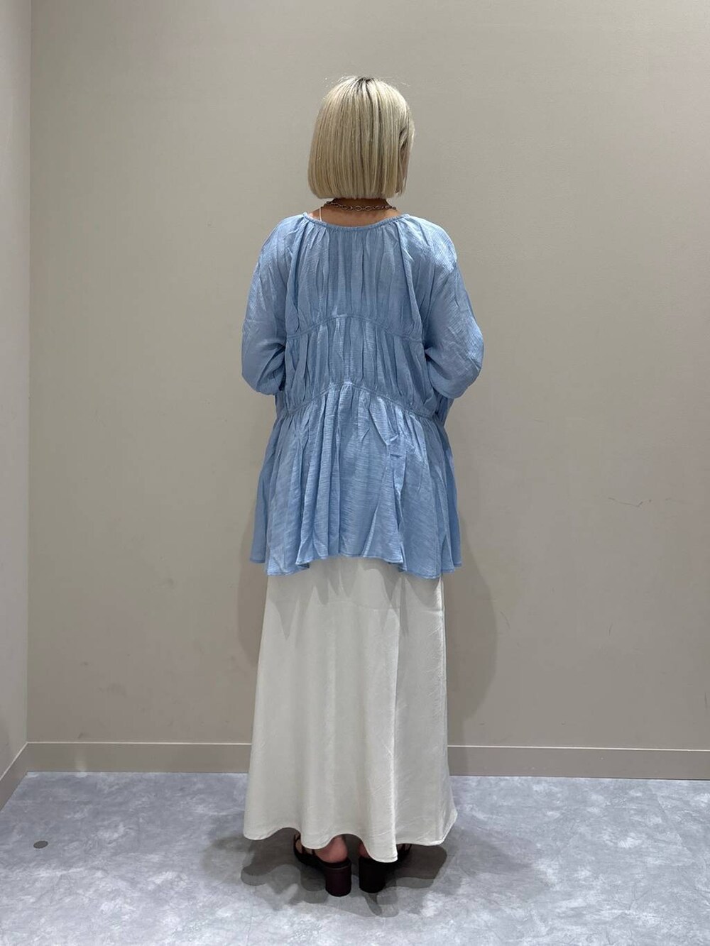 ブルー系のシャツ/ブラウス、ホワイト系のスカート、ブラウン系のサンダルを着用したレディースの夏コーディネートの3枚目の写真