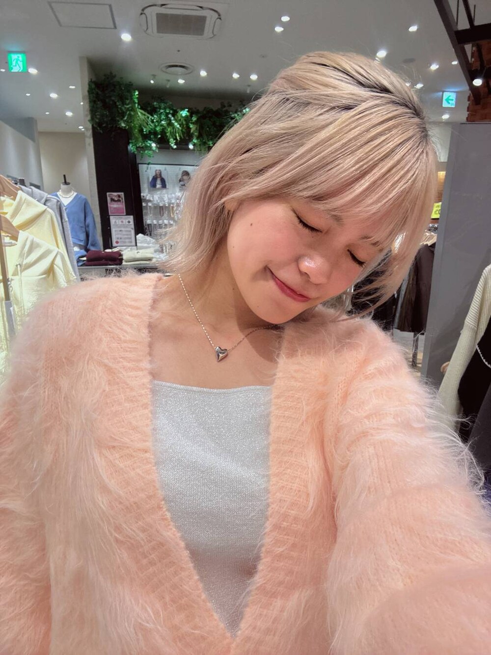 シルバー系のタンクトップ、ピンク系のカーディガン/ボレロ、シルバー系のネックレスを着用したレディースの秋コーディネートの3枚目の写真