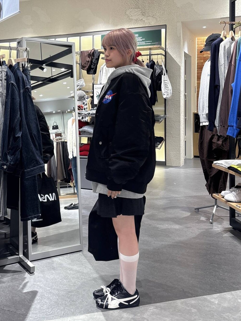 グレー系のスカート、グレー系のTシャツ/カットソー、ブラック系のブルゾンを着用したレディースの秋コーディネートの3枚目の写真