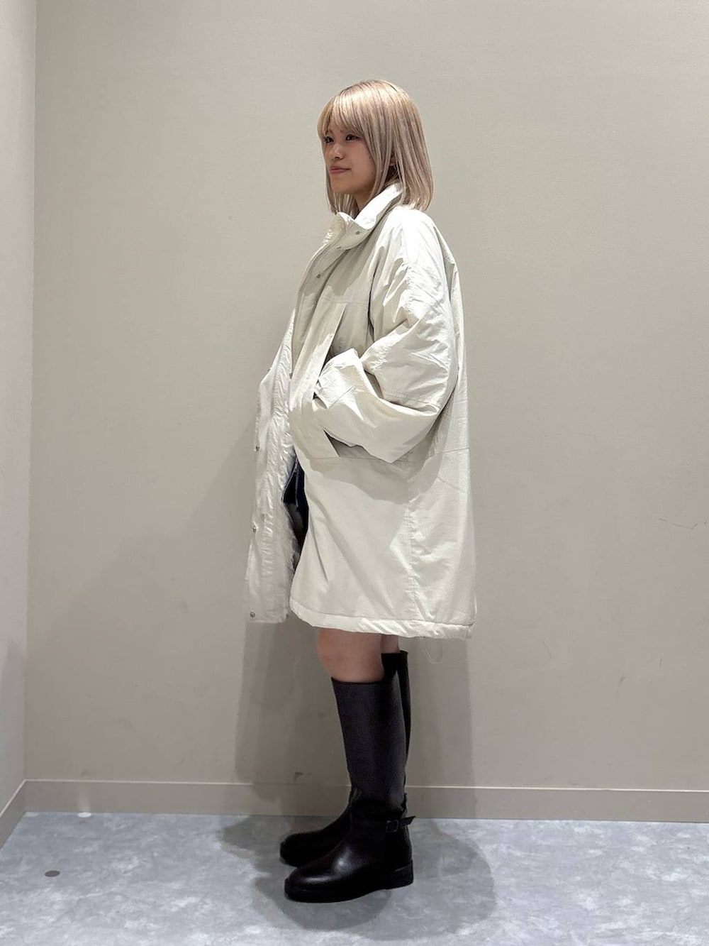 ブルー系のカーディガン/ボレロ、ホワイト系のブルゾン、ブラウン系のブーツを着用したレディースの秋コーディネートの4枚目の写真