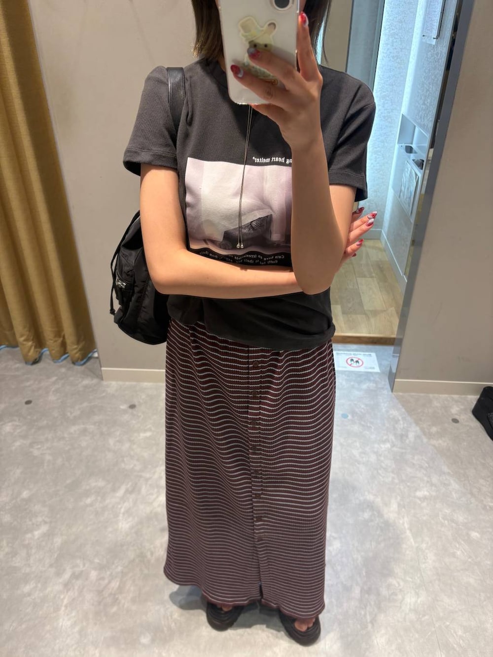 グレー系のTシャツ/カットソー、ブラック系のショルダーバッグ、ブラウン系のサンダルを着用したレディースの夏コーディネートの4枚目の写真