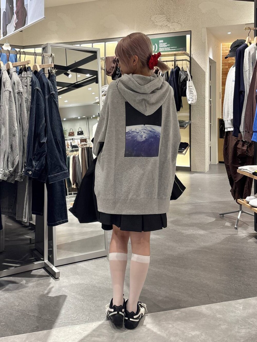 グレー系のスカート、グレー系のTシャツ/カットソー、ブラック系のブルゾンを着用したレディースの秋コーディネートの2枚目の写真