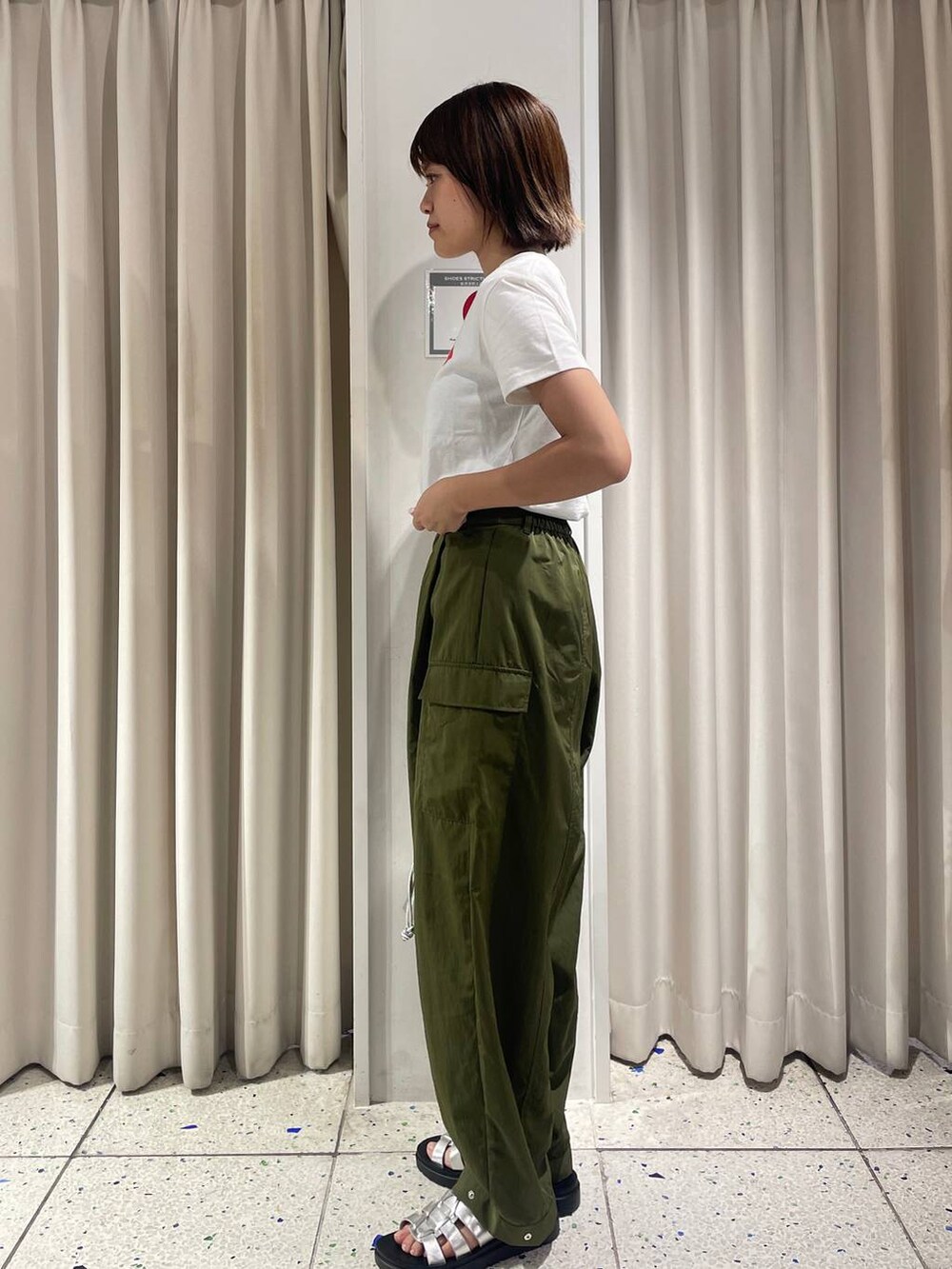 グリーン系のカーゴパンツ、ホワイト系のTシャツ/カットソー、シルバー系のスニーカーを着用したレディースの夏コーディネートの2枚目の写真