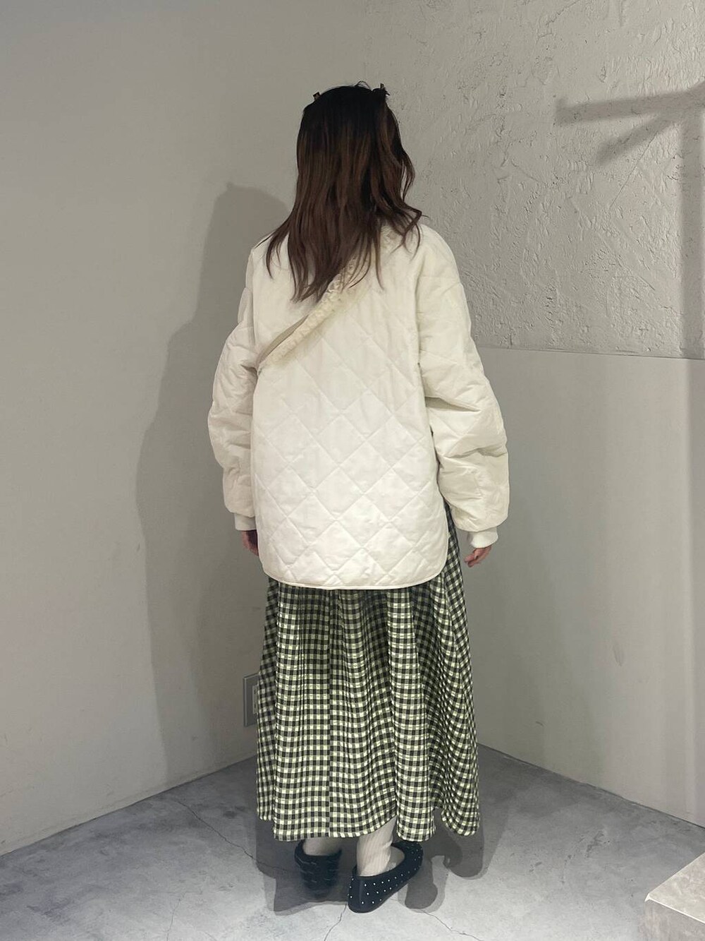 グリーン系のワンピース、ホワイト系のミリタリージャケット、ブラック系のバレエシューズを着用したレディースの冬コーディネートの3枚目の写真