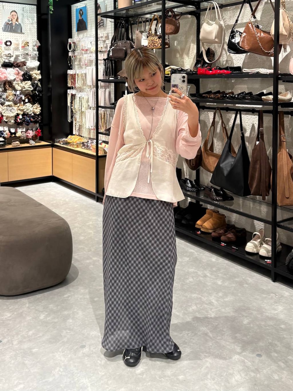 ピンク系のTシャツ/カットソー、ホワイト系のベスト、グレー系のスカートを着用したレディースの冬コーディネートの2枚目の写真