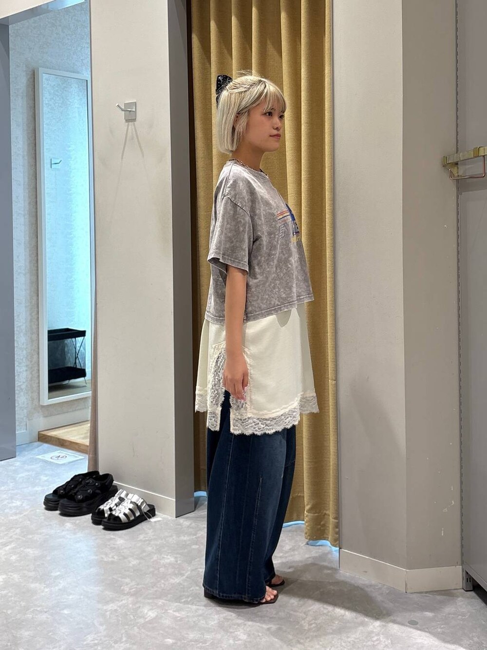 ブルー系のデニムパンツ、ブラウン系のサンダル、グレー系のTシャツ/カットソーを着用したレディースの夏コーディネートの4枚目の写真