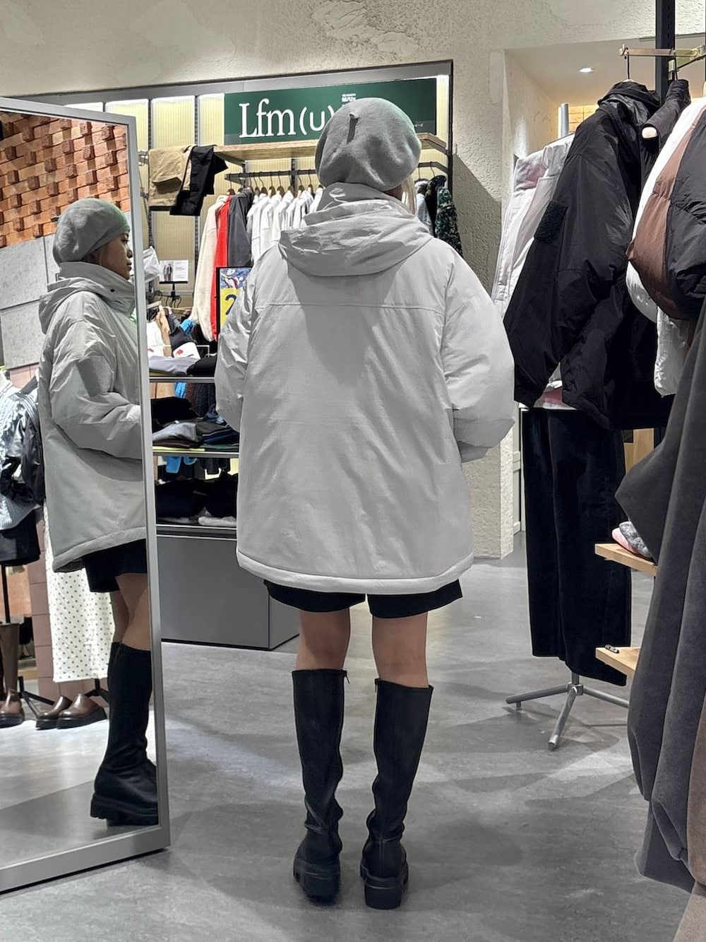 グレー系のその他パンツ、グレー系のダウンジャケット/コート、ブラック系のブーツを着用したレディースの秋コーディネートの3枚目の写真