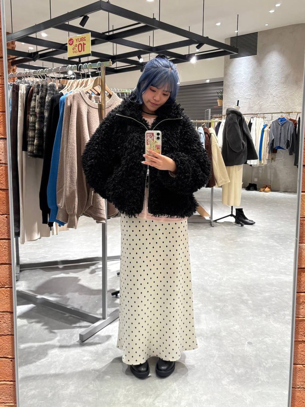 ホワイト系のスカート、ピンク系のTシャツ/カットソー、ブラック系のブーツを着用したレディースの冬コーディネートの6枚目の写真