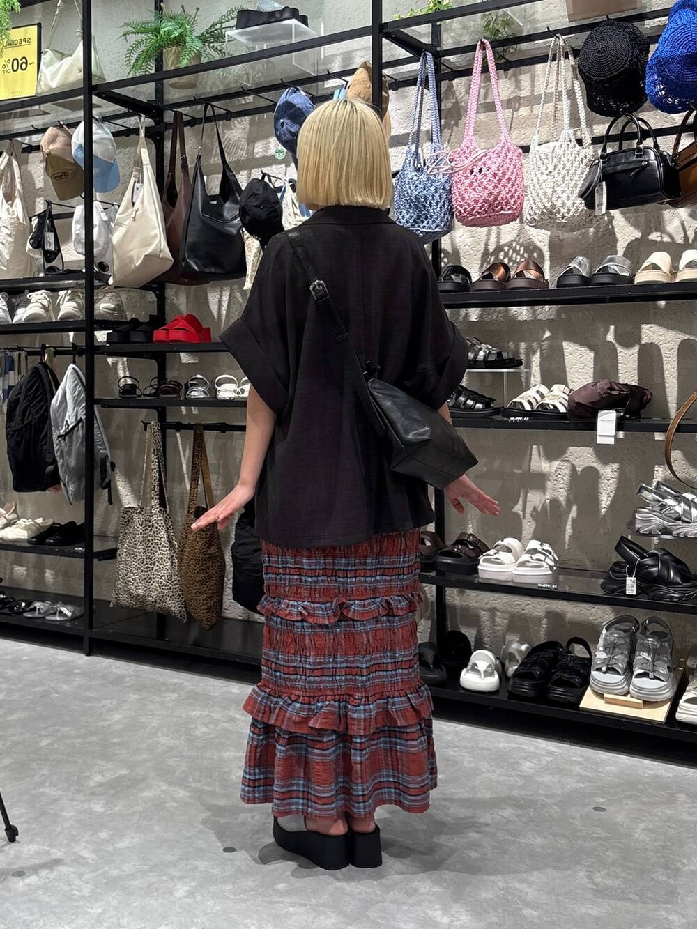 シルバー系のサンダル、ホワイト系のTシャツ/カットソー、ブラック系のショルダーバッグを着用したレディースの夏コーディネートの3枚目の写真