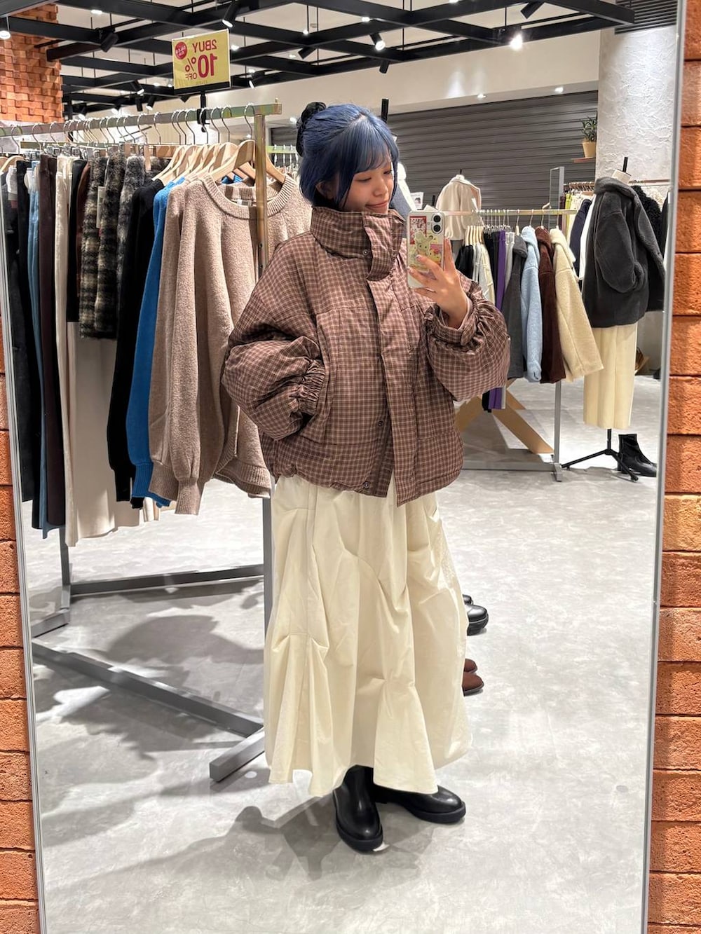 ブラック系のブーツ、ブラウン系のブルゾン、ホワイト系のスカートを着用したレディースの冬コーディネートの7枚目の写真