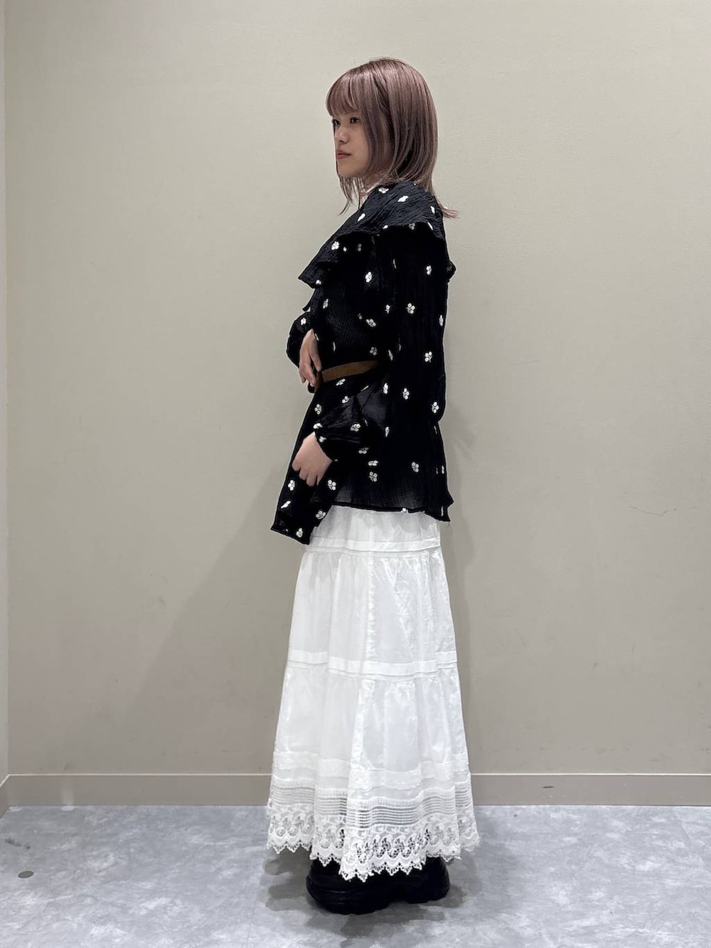 ブラウン系のローファー、ホワイト系のスカート、ブラック系のワンピースを着用したレディースの春コーディネートの2枚目の写真